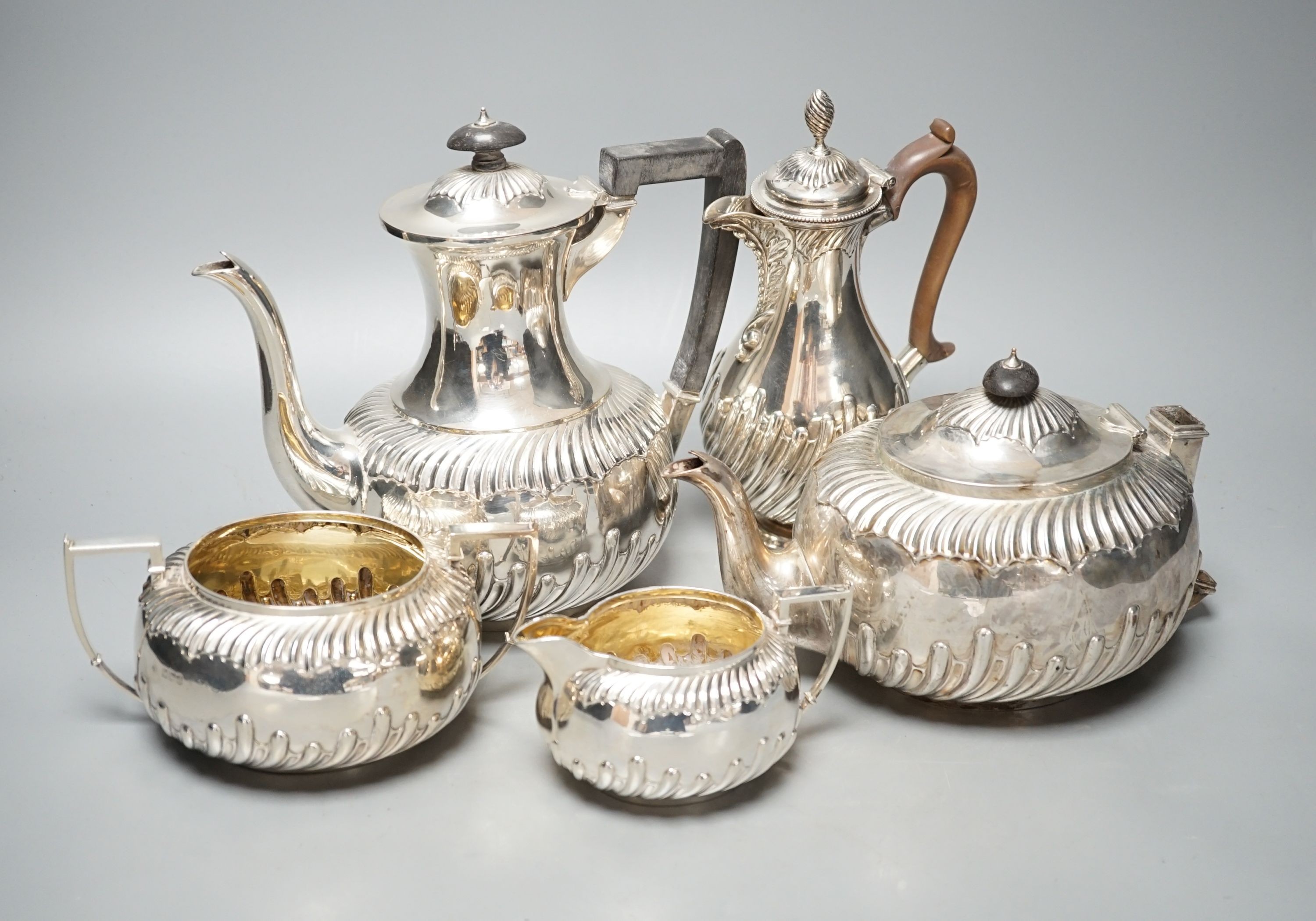 A late Victorian repousse silver four piece tea set, Martin, Hall & Co, Sheffield, 1892, (a.f.) together with a Victorian silver hot water jug, Charles Stuart Harris, London, 1884, gross 60.5oz.